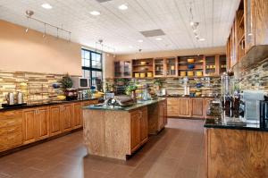 Homewood Suites by Hilton Slidell في سليدل: مطبخ كبير مع دواليب خشبية ومغسلة