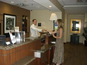 een man en een vrouw die handen schudden aan een toonbank bij Hampton Inn and Suites Pueblo/North in Pueblo