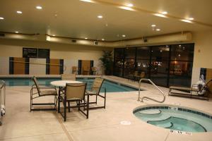 a swimming pool with a table and chairs next to a table and a tablektop at Hampton Inn and Suites Pueblo/North in Pueblo