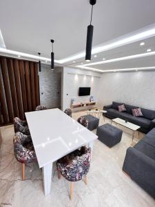 ein Wohnzimmer mit einem weißen Tisch und Stühlen in der Unterkunft vacance et confort les sablettes in Mohammedia