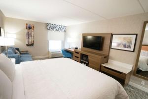 a hotel room with a bed and a flat screen tv at Hampton Inn Clarks Summit in Clarks Summit