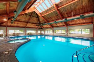 uma grande piscina interior com tecto de madeira em DoubleTree by Hilton Port Huron em Port Huron