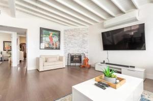 a living room with a large flat screen tv on a wall at Walk 2 Beach Parking A C W D 15min 2LAX Remodel in Manhattan Beach