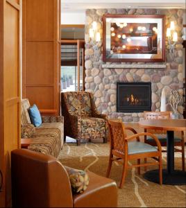 a living room with a fireplace and a stone wall at Hilton Garden Inn Cedar Falls Conference Center in Cedar Falls