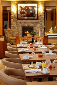 a restaurant with tables and chairs and a fireplace at Hilton Garden Inn Cedar Falls Conference Center in Cedar Falls