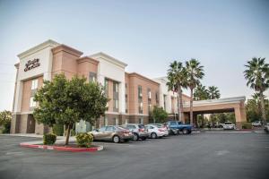 een hotel met auto's geparkeerd op een parkeerplaats bij Hampton Inn & Suites Lathrop in Lathrop