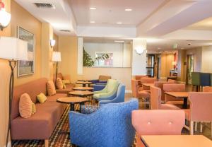 a waiting room with couches and tables and chairs at Hampton Inn & Suites Lathrop in Lathrop