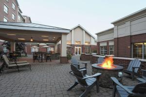 a patio with a fire pit and chairs and tables at Homewood Suites by Hilton Albany in Albany