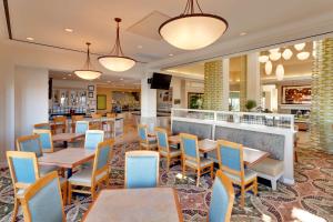 a restaurant with tables and chairs and a bar at Hilton Garden Inn Sacramento Elk Grove in Elk Grove