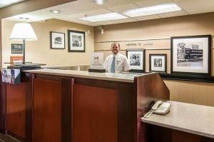 a man standing behind a reception desk in a office at Hampton Inn Boise - Airport in Boise