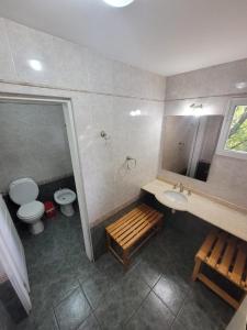 a bathroom with a sink and a toilet and a mirror at Casa Lago Argentino in El Calafate
