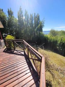 eine hölzerne Promenade mit einer Bank darüber in der Unterkunft Casa Lago Argentino in El Calafate