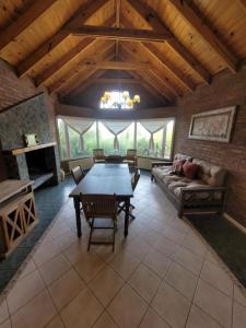 ein großes Wohnzimmer mit einem Tisch und einem Sofa in der Unterkunft Casa Lago Argentino in El Calafate