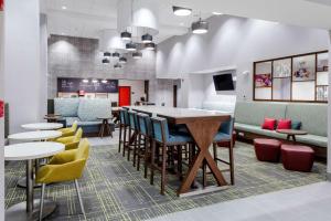 Hampton Inn & Suites Avon Indianapolis في Avon: مطعم بطاولات وكراسي وبار