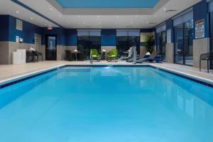 a large swimming pool with blue water in a hotel lobby at Hampton Inn & Suites Avon Indianapolis in Avon