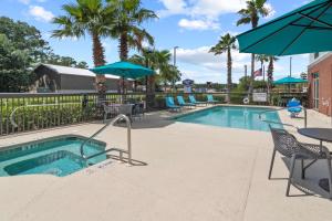 een zwembad met stoelen en parasols in een resort bij Hampton Inn Kingsland in Kingsland