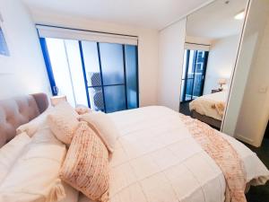 a bedroom with a bed and a mirror at Adelaide City Loft in Adelaide