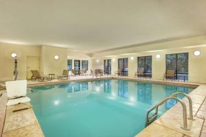 a pool in a hotel with tables and chairs at Hampton Inn Duncan in Duncan