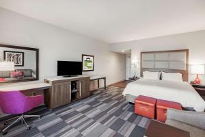 ein Hotelzimmer mit einem Bett und einem Flachbild-TV in der Unterkunft Hampton Inn North Little Rock McCain Mall, AR in North Little Rock