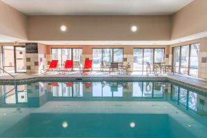 a large swimming pool with red chairs and tables at Hampton Inn Madison East Towne Mall Area in Madison