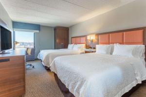 a hotel room with two beds and a flat screen tv at Hampton Inn Madison East Towne Mall Area in Madison +18 photos