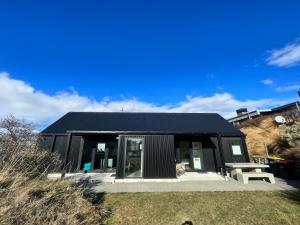 a black house with a black roof at Mary Hut in Lake Tekapo
