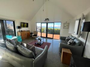 a living room with couches and a large window at Mary Hut in Lake Tekapo