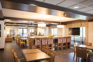 a restaurant with tables and chairs and a bar at Hampton Inn Pensacola-Airport in Pensacola