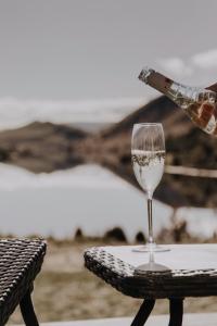 una persona está sosteniendo una copa de vino en una mesa en Meadowbank Lakehouse, en Ellendale