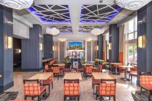 a restaurant with wooden tables and chairs and blue ceilings at Hampton Inn & Suites Raleigh-Durham Airport-Brier Creek in Raleigh
