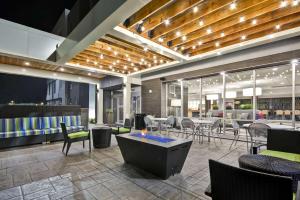 a restaurant with a bar with chairs and tables at Home2 Suites By Hilton Hanford Lemoore in Hanford