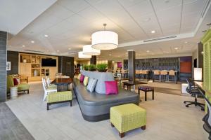 a lobby with a couch and tables and chairs at Home2 Suites By Hilton Hanford Lemoore in Hanford