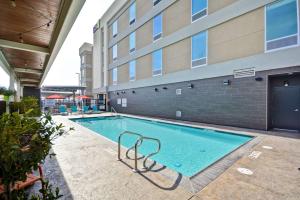 a swimming pool in front of a building at Home2 Suites By Hilton Hanford Lemoore in Hanford