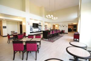 a restaurant with tables and chairs and a bar at Hampton Inn and Suites Sandusky/Milan in Milan