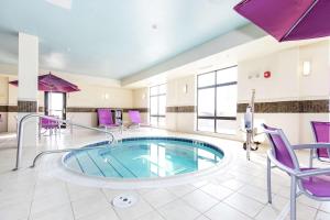 a pool in a room with purple chairs at Hampton Inn and Suites Sandusky/Milan in Milan