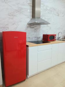 a kitchen with a red refrigerator and a microwave at Apartamentos Tierra Bobal in Requena