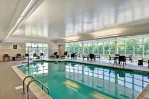 una piscina con mesas y sillas en un edificio en Homewood Suites By Hilton Schenectady en Schenectady