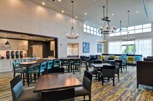 um restaurante com mesas e cadeiras e um bar em Homewood Suites By Hilton Schenectady em Schenectady
