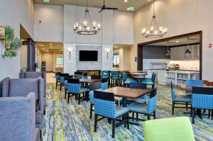 ein Restaurant mit Tischen und Stühlen und eine Küche in der Unterkunft Homewood Suites By Hilton Schenectady in Schenectady