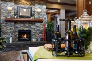 Una chimenea en una sala de estar con botellas de vino en una mesa. en Hilton Garden Inn Clifton Park, en Clifton Park