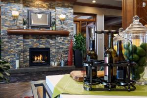 a fireplace in a living room with wine bottles on a table at Hilton Garden Inn Clifton Park in Clifton Park