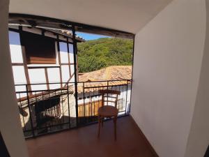 a chair sitting on a balcony with a view at Casa de tía Patricia in Montemayor del Río