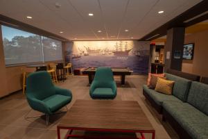 uma sala de espera com sofás e uma mesa e cadeiras em Tru By Hilton Norfolk Airport, Va em Virginia Beach