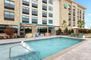 弗赖拉辛Tru By Hilton Frisco Dallas, Tx的建筑物前的游泳池