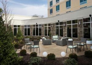 eine Terrasse mit Stühlen und Tischen vor einem Gebäude in der Unterkunft Hilton Garden Inn Olive Branch, Ms in Olive Branch