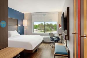 弗赖拉辛Tru By Hilton Frisco Dallas, Tx的一间卧室，配有一张床、一张桌子和一把椅子 更多32张照片