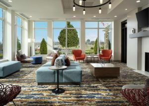 a living room with a blue couch and chairs at Hilton Garden Inn Olive Branch, Ms in Olive Branch