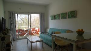 een woonkamer met een blauwe bank en een tafel bij Departamento de dos ambientes a 60 metros de la plaza de Adrogué in Adrogué