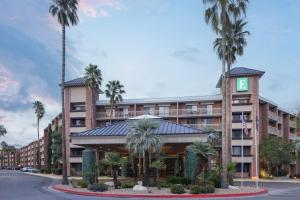 a hotel with palm trees in front of a building at Embassy Suites by Hilton Tucson East in Tucson