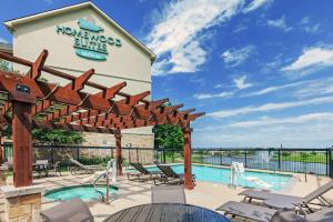 a pool at a hotel with chairs and a sign that reads homnox suites at Homewood Suites by Hilton Waco in Waco